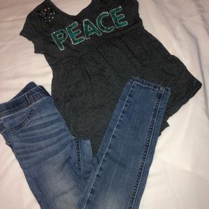 “Peace” bling shirt and skinny jeans.